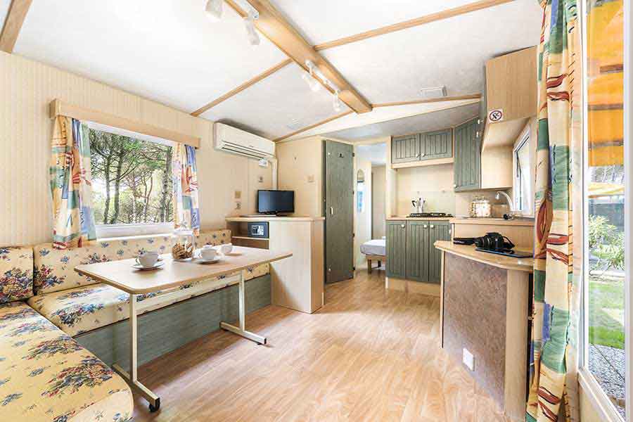 Living room-kitchen of the mobile home with table and sofa