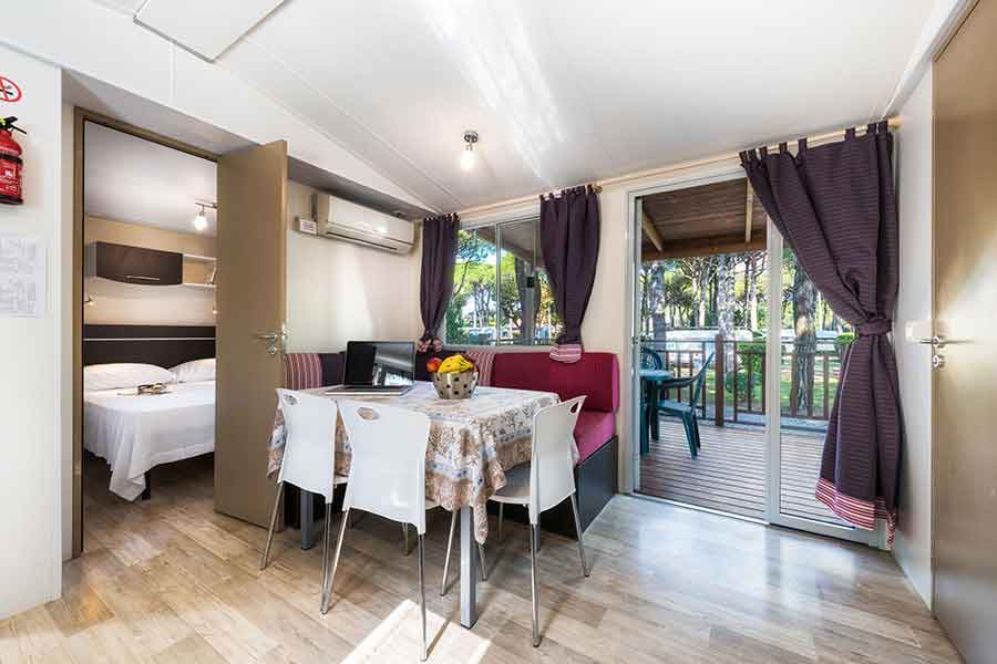 Living room-kitchen of the maxi caravan overlooking the equipped terrace