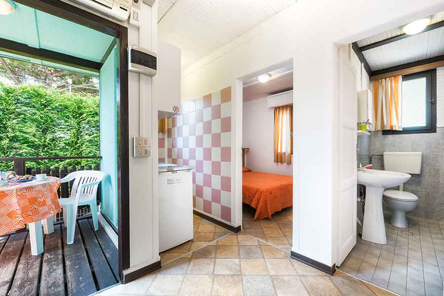 Mini-bungalow interior with view of double bedroom, bathroom, kitchen and outdoor space