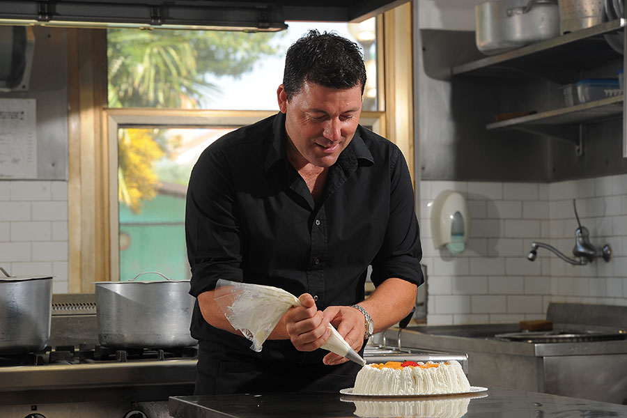 Chef in the kitchen decorating a cake