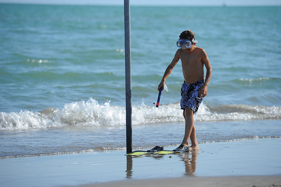 Mother and daughter digging a hole in the sand